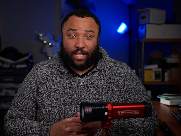 New to GVM 1 Image capturing a creator during a review or tutorial, analyzing the portable spotlight.