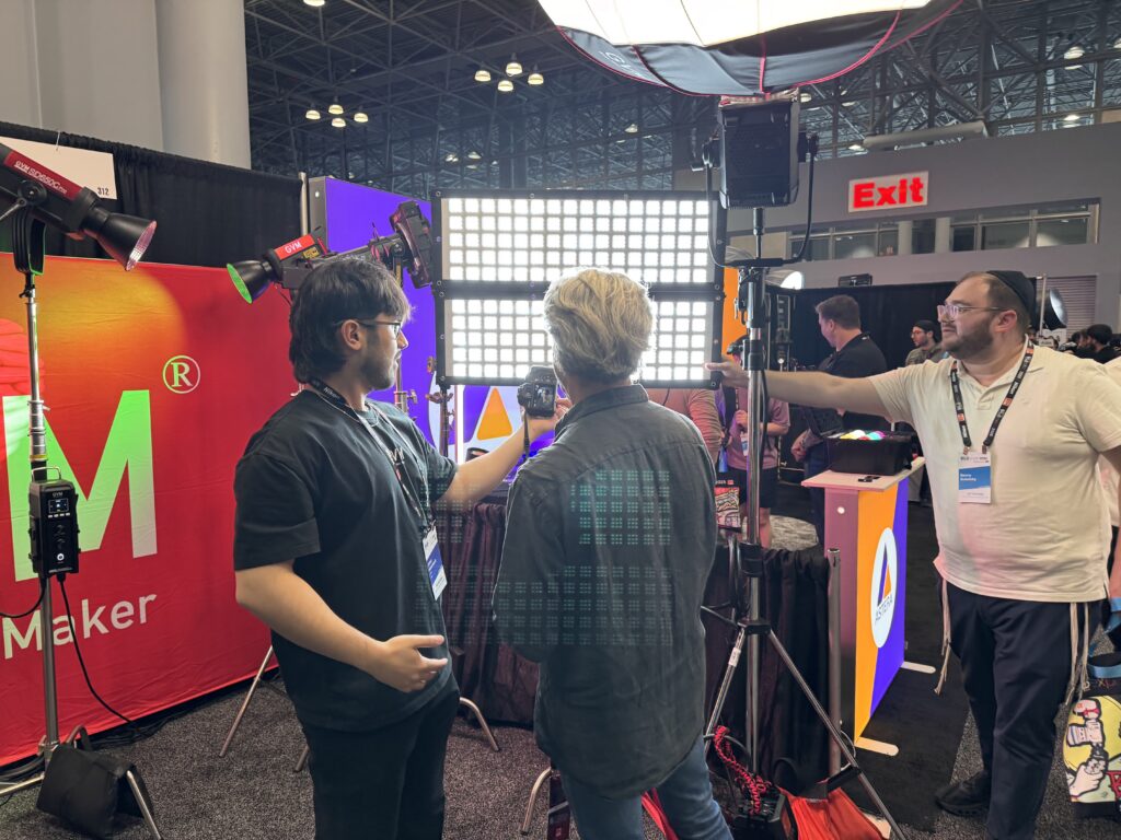 Beyond the Booth: GVM Unveils the Future of Lighting at BILD Expo 2025 6 A GVM product expert explains the precision and versatility of the Ziptile modular lighting system to a group of interested filmmakers at the GVM booth during BILD Expo 2025.