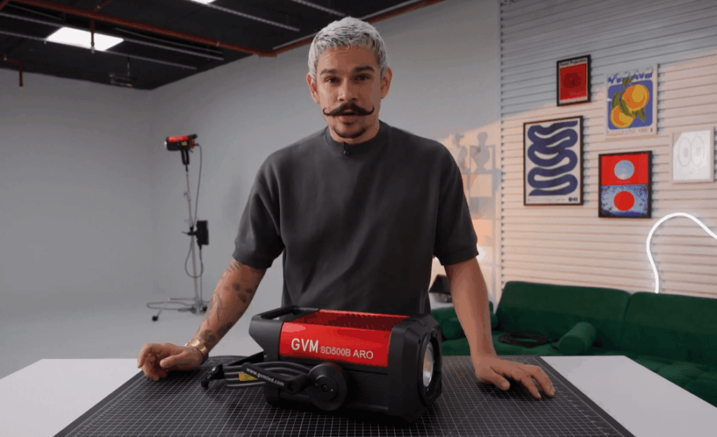 LED vs. Tungsten vs. HMI: Choosing the Right Film Light for Your Project 1 A filmmaker reviewing the GVM COB film light on a studio desk.