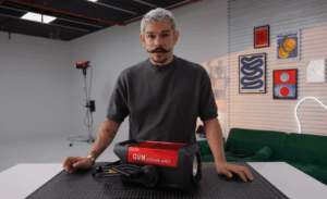A filmmaker in a studio discusses different types of film lights, using a GVM COB light on the desk as a modern example.