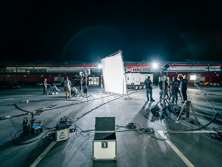 GVM PRO SD650B: The Cinematic Video Lighting Solution Built for Demanding Outdoor Shoots 2 Daytime ANA commercial set with power unit being connected, a camera operator, and video lighting.