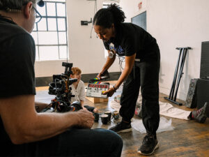 A film production crew meticulously setting up filming light and camera equipment on set, embodying the practical application of cinematic lighting techniques and equipment selection for professional video production.