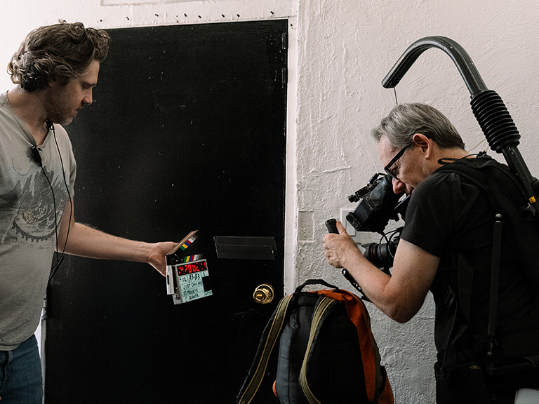 Mastering Lighting for Video Production at Movie Studio 2 Film crew members collaborate on set, planning camera and lighting for video production setups.
