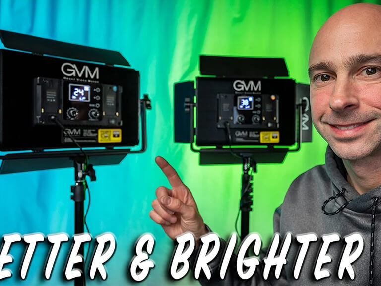 Podcast Background Lighting Ideas: Add Ambiance & Depth to Your Studio 2 A content creator smiling and gesturing towards two GVM RGB LED panel lights, emphasizing "Better & Brighter" illumination for video podcasts.