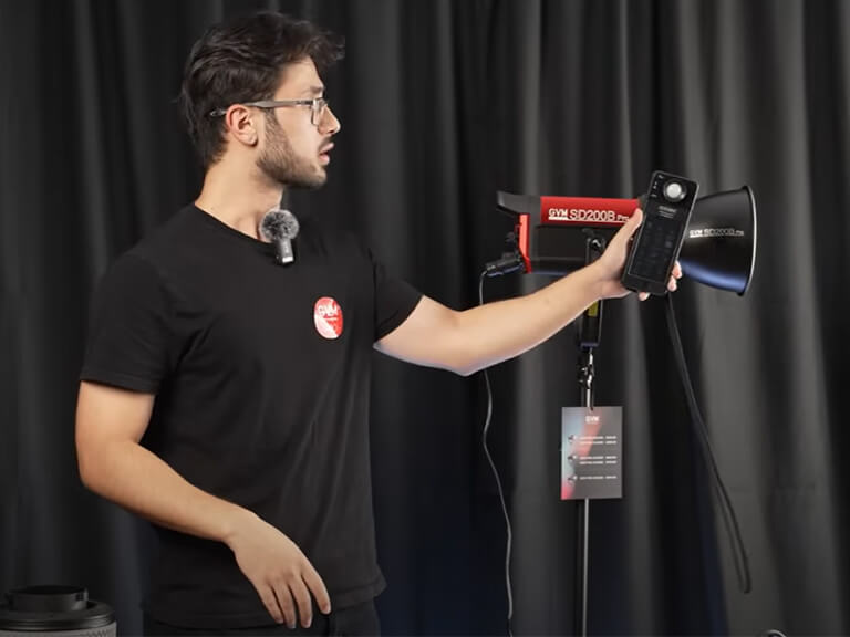 Say Goodbye to Flat & Shadowy Photos! A Beginner's Guide to Photography Lighting 3 A man in a studio actively using a handheld light meter to precisely measure the output of a GVM photography light on a stand.