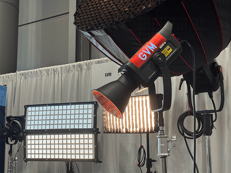 NAB Show New York Highlights: GVM's Breakthrough in LED Lighting 3 A GVM high-power COB spotlight, possibly from the Reign or AIO series, displayed alongside a multi-unit Flathead or ZipTile LED panel array at the GVM booth.