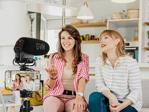 Women vlogging in a kitchen using GVM QX-6 shotgun microphone mounted on a smartphone for interviews.