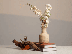 Professional artificial light photography for still life featuring a white flower vase on books with soft shadowsf