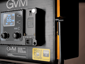 The side detail of the GVM LED video light: a close-up of the battery compartment/interface area and the control panel (with OLED screen and knobs), showcasing the device’s installation/power interface design, suitable for professional video shooting lighting systems.