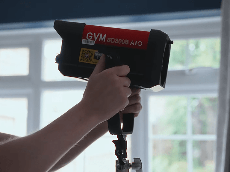 Best Studio Light for Video Shooting 4 Best Studio Light for Video Shooting - GVM SD300B AIO being adjusted on a stand, showcasing its portable design and ergonomic handle for easy positioning.